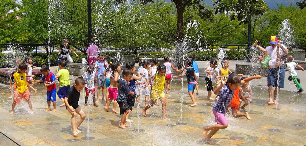 Children playing in an outdoor water spray park.