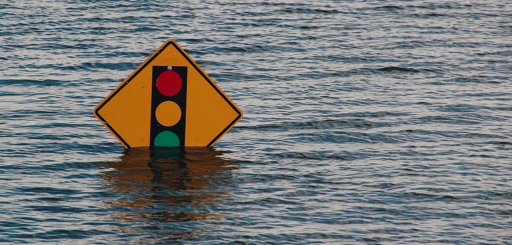 a street sign partially underwater from a flood