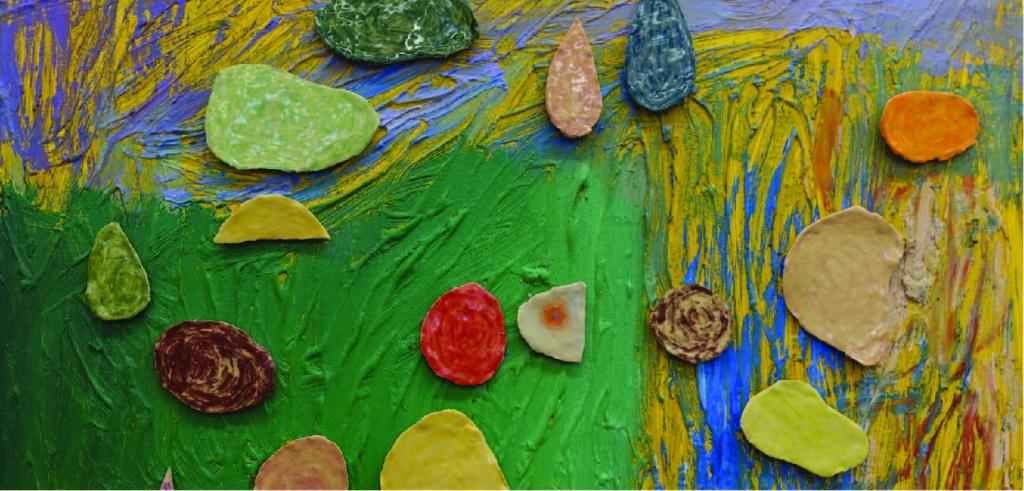 Textured painted background with different colored clay pieces laying on top.