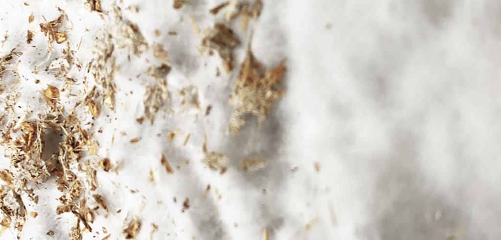 Brown and gold flakes on white cottonlike material.