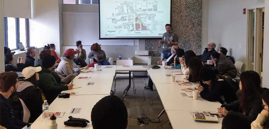 people around a table with a projector presentation