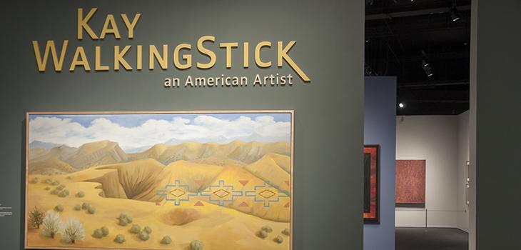 Entrance to WalkingStick exhibition with name and landscape painting