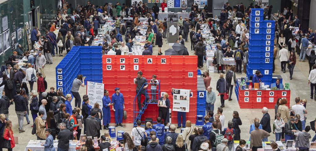 Many people gathered in a large gallery space.