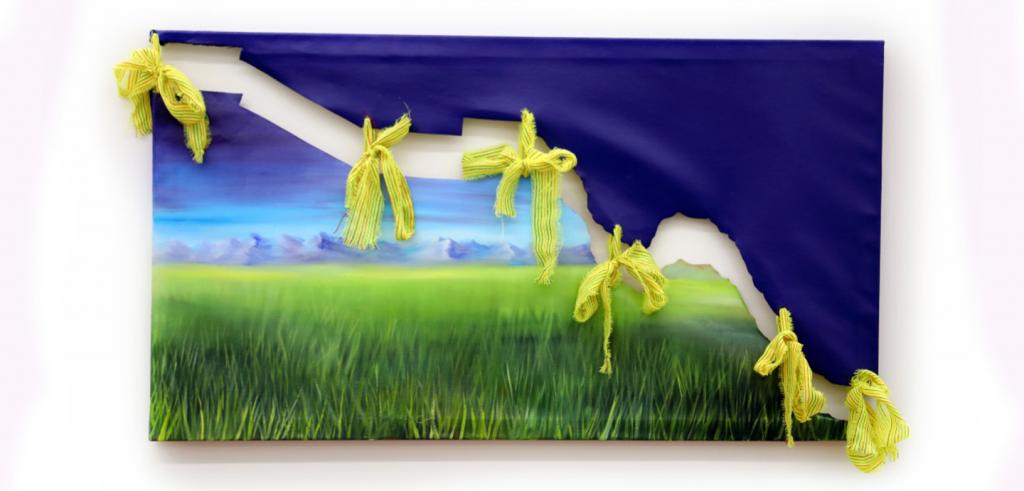 Dark blue fabric attached to a cut piece of a painting depicting a landscape, held together with bright yellow ribbons.