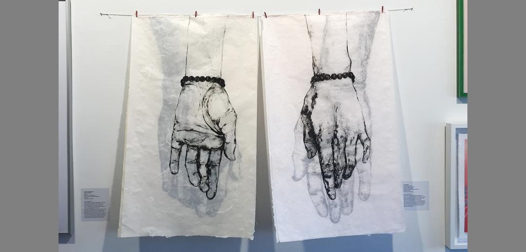 Four ink drawings of two hands are layer on on translucent paper