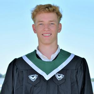 student with short light colored hair, wearing graduation robe