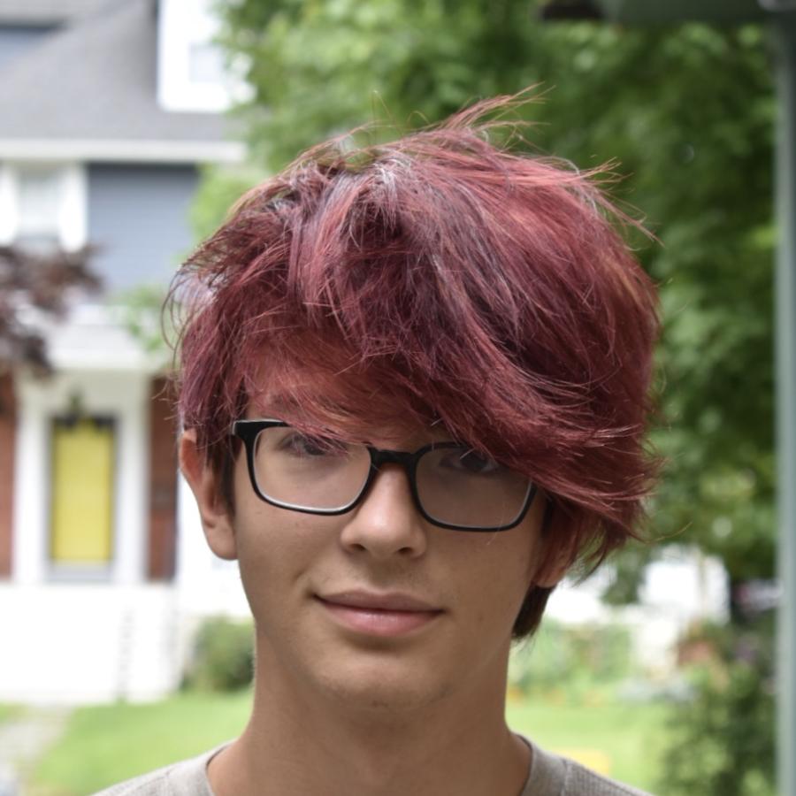 Student wearing glasses with trees in background