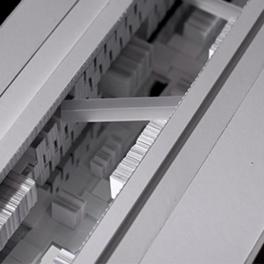 Black and white photograph of close-up of white model made of paper and paper products, showing sunken highly textured space.