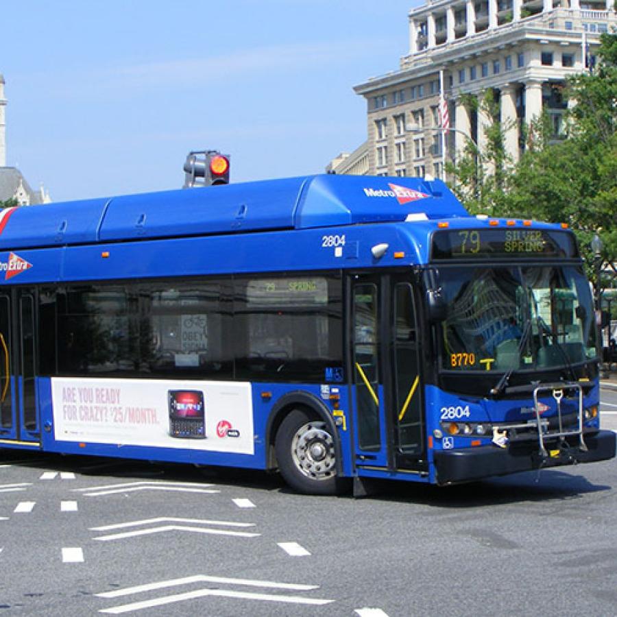 a blue city bus making a turn on a road
