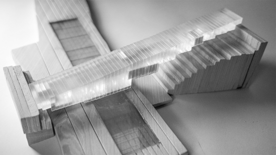 Photograph of model made of wood for the site and a mass composed of vertical plexiglass layers glued together, with opaque masses embedded within.