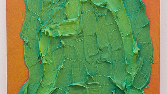 Close-up color photo of a canvas with 2d orange background covered in 3d textured green paint in an abstract shape.