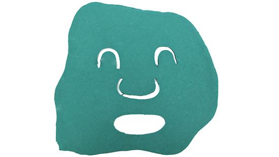Teal paper cutout in the shape of a face mask on a white background. 