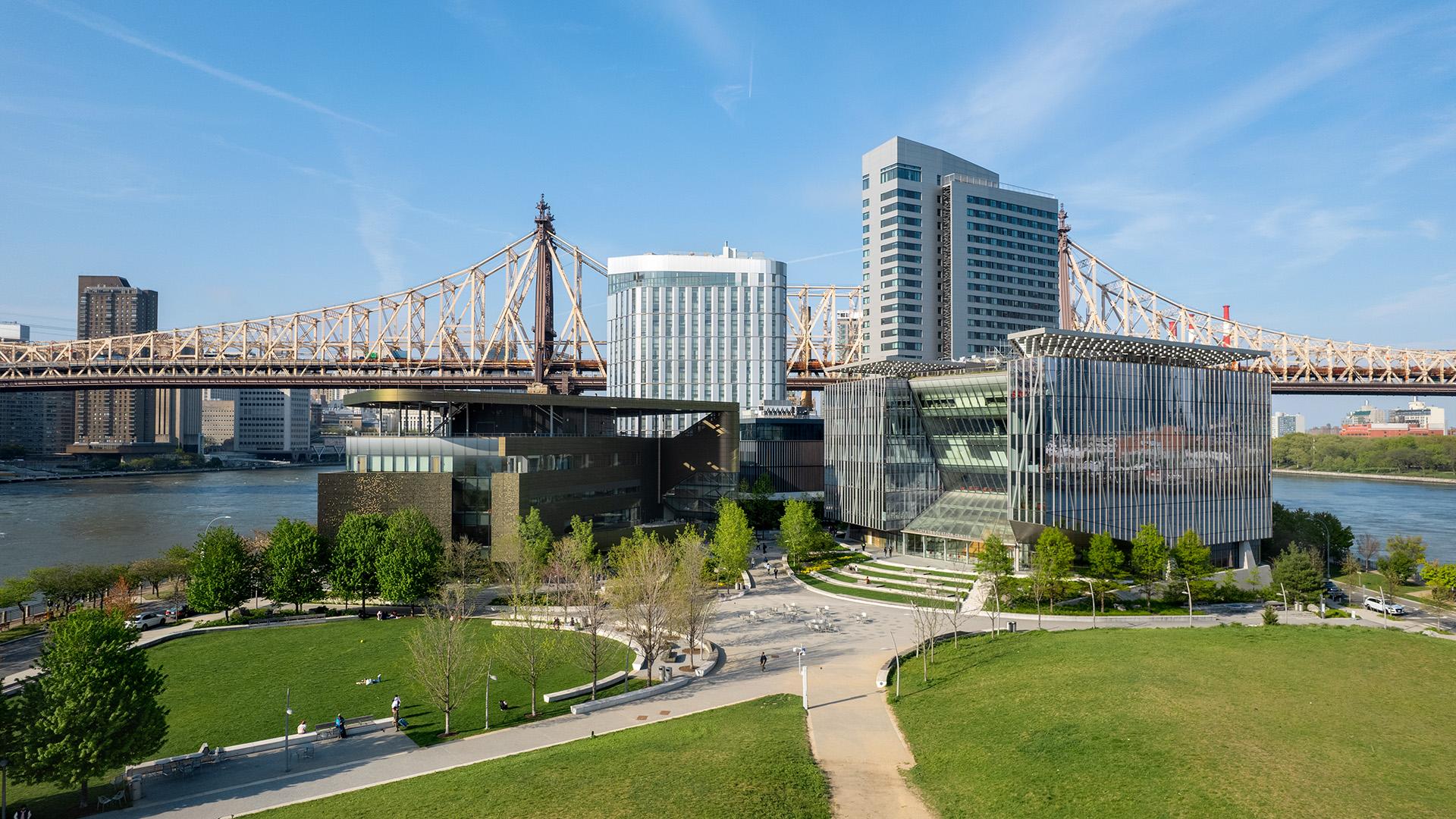 a grouping of large buildings surrounded by water with bridges and the sky in the background