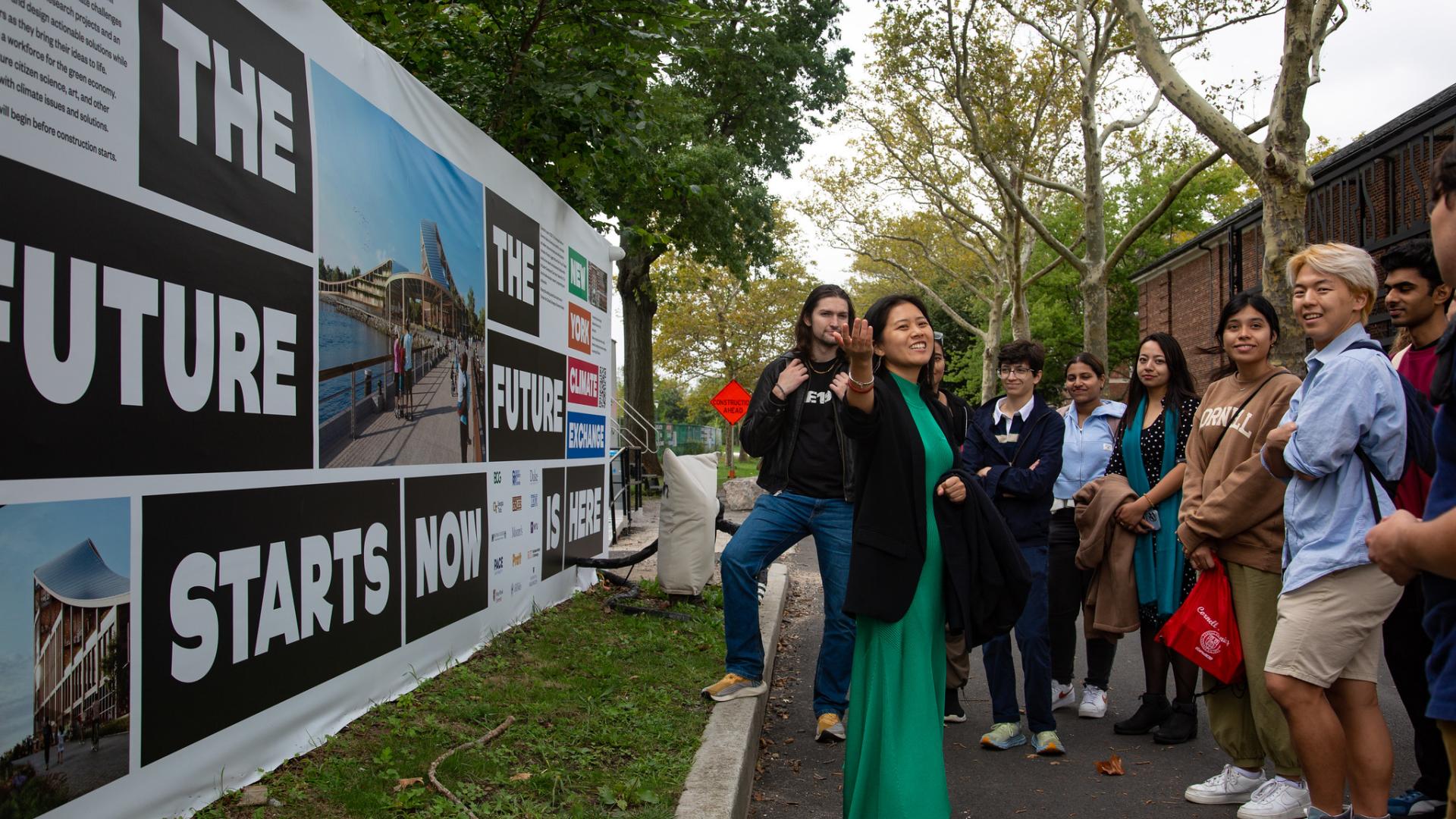 A group of people standing outside looking at a mural