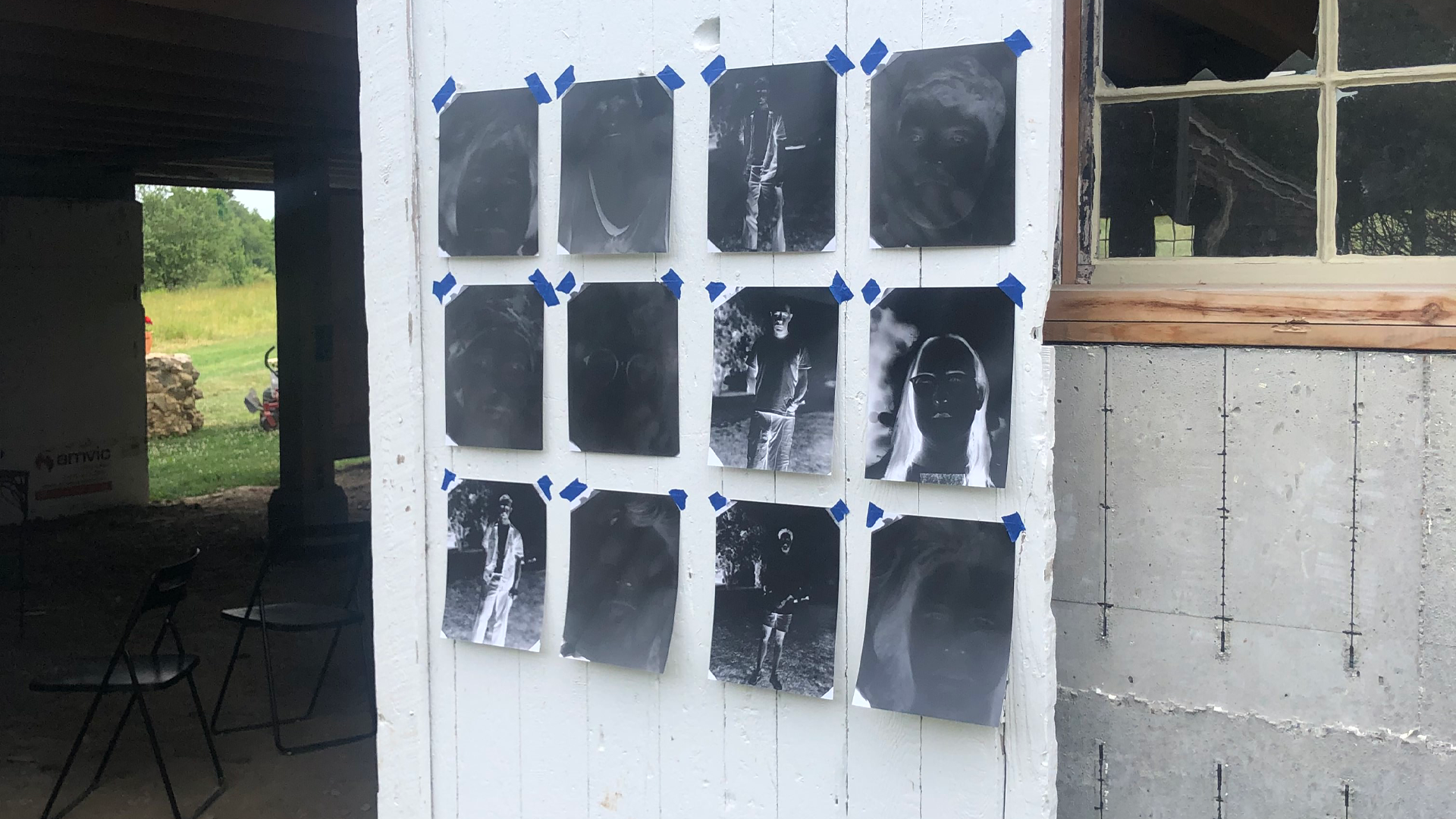 A series of printed images taped to a white barn door.