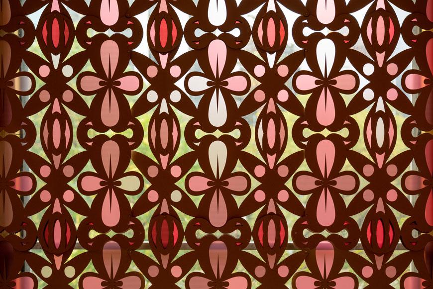 A repeating geometric pattern in shades of pink and red. 