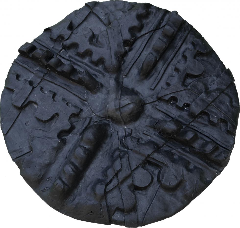 Black wax circle with a dome imprint in the middle, divided into 4 corner parts.