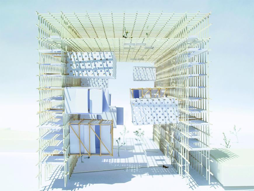 Photograph of basswood and paper model showing rectangular framework made of basswood lattice with rectangular masses made of paper cantilevering from the sides of the frame inwards.