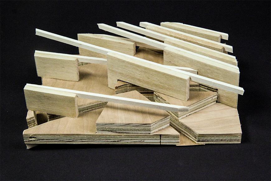 Photograph of section model made of layered plywood with slots and basswood and vertical pine boards arrayed diagonally on top of it.