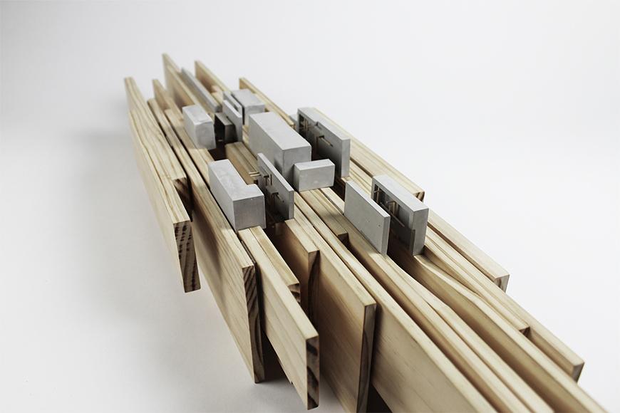 Photograph of model made of vertical wood boards as the site, with rockite boxes and basswood sticks embedded in between the boards and on top of them.