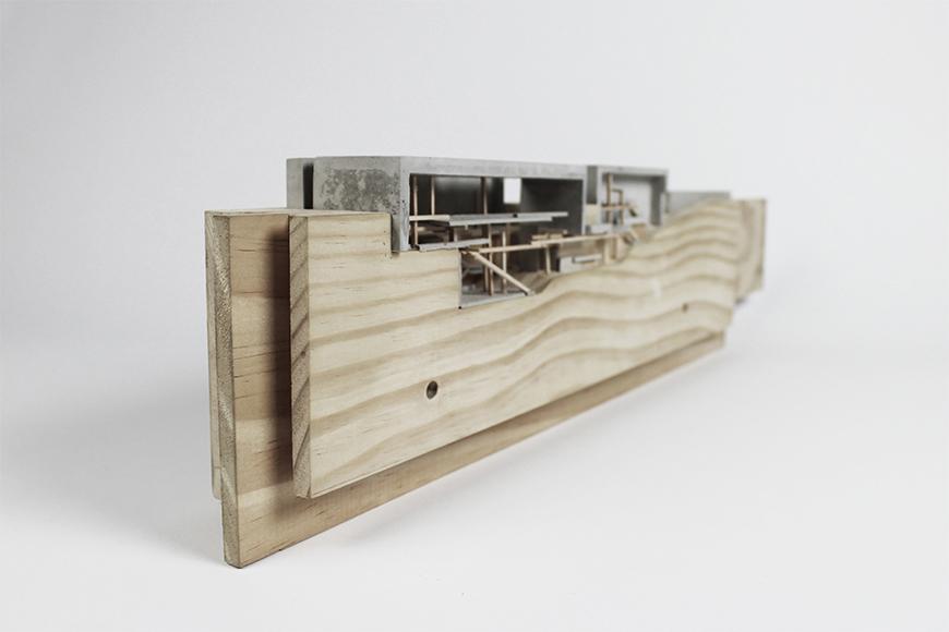 Photograph of model made with vertical wooden boards as the site with rockite boxes set into the top of the boards and basswood sticks representing interior structure.