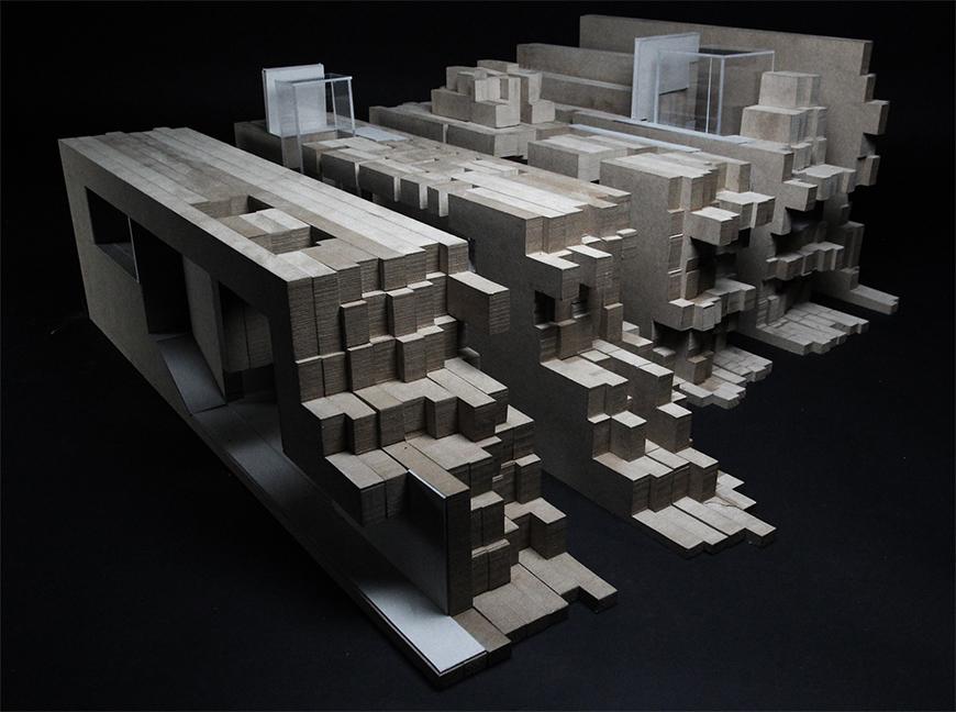 Photograph of model made from paper, basswood, and chipboard layered together into vertical sections of chipboard assembled into a topological mass.