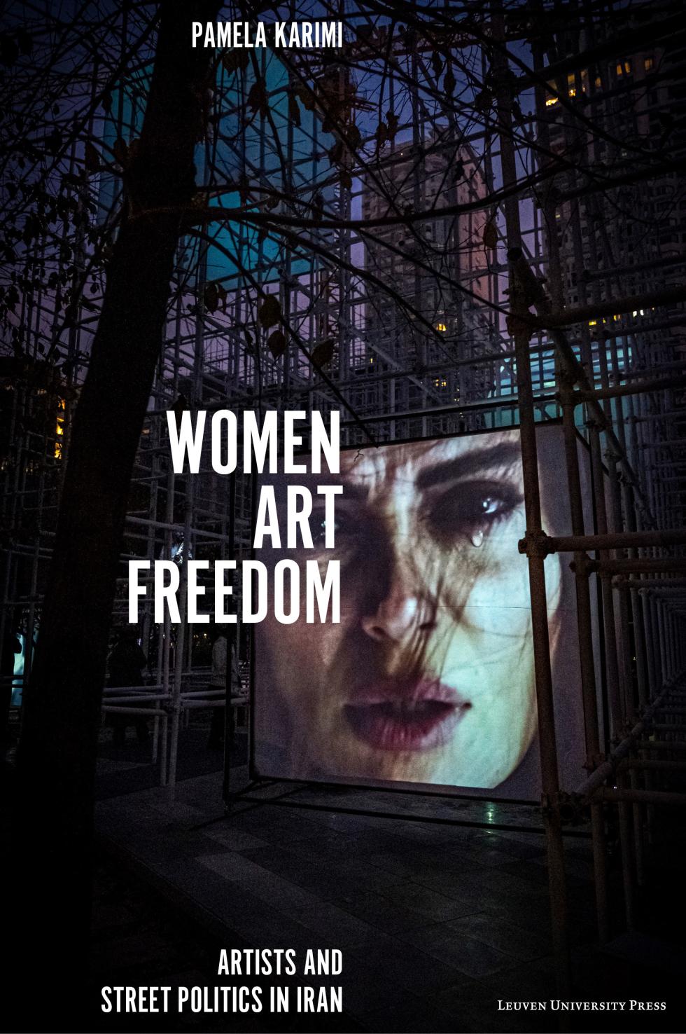 Book cover of 'Women, Art, Freedom: Artists and Street Politics in Iran' by Pamela Karimi. The cover features an image of an art installation within a room of metal scaffolding, with an image of a woman crying projected in the middle. The title and author's name are overlaid in white text.