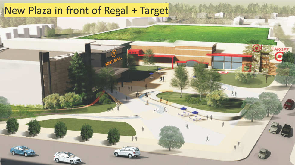 Entrance to Regal movie theatre and Target store. Pictured are 3 sidewalks with people walking and areas of grass and trees in between them with cars along the street.
