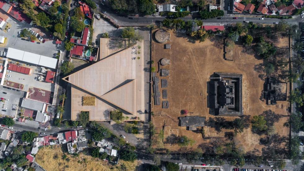 A high angle view of a building nestled within a residential area, showcasing an aerial perspective of the suburb with trees surrounding the urban design.