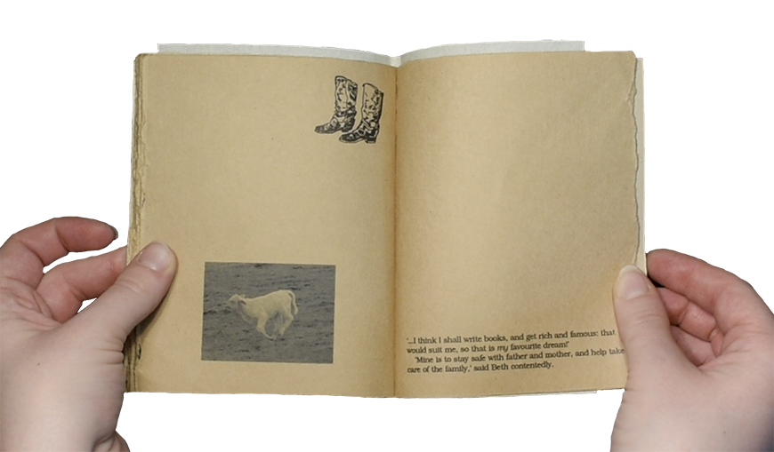 Light skinned hands holding a handmade book open. The sepia pages are nearly blank; on the left page is a small line drawing of cowboy boots with a realistic image of a cow printed below and the right page has small text at the bottom. 