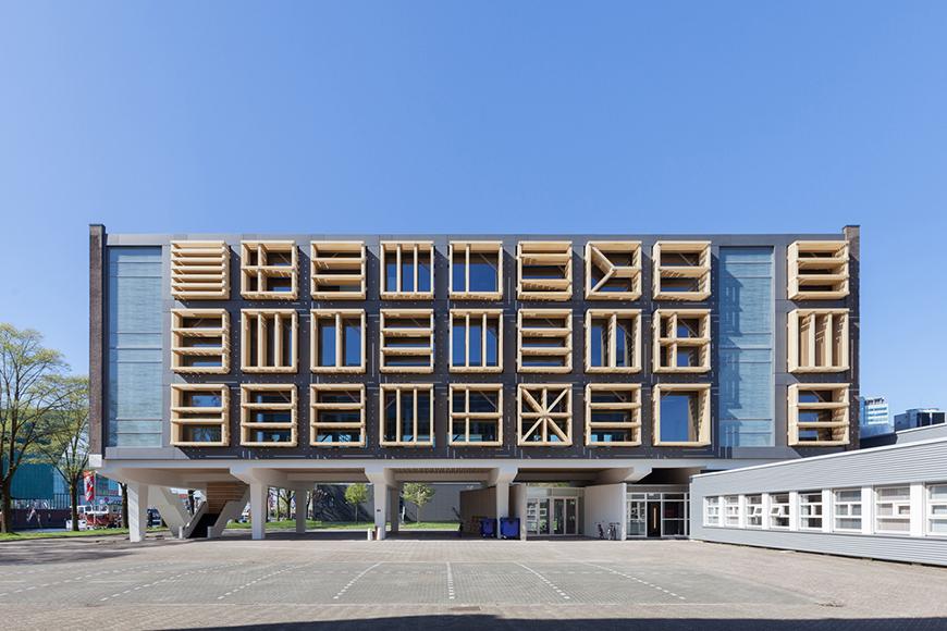 A building whose windows and facade are covered by a series of geometric screens. 