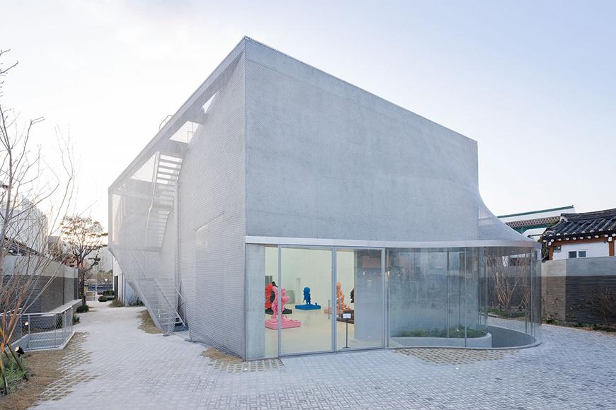 A white building covered in a permeable netting material.