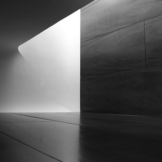 A black and white photo of a curved wall and floor