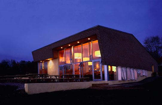 Evening view of restaurant with interior lit.