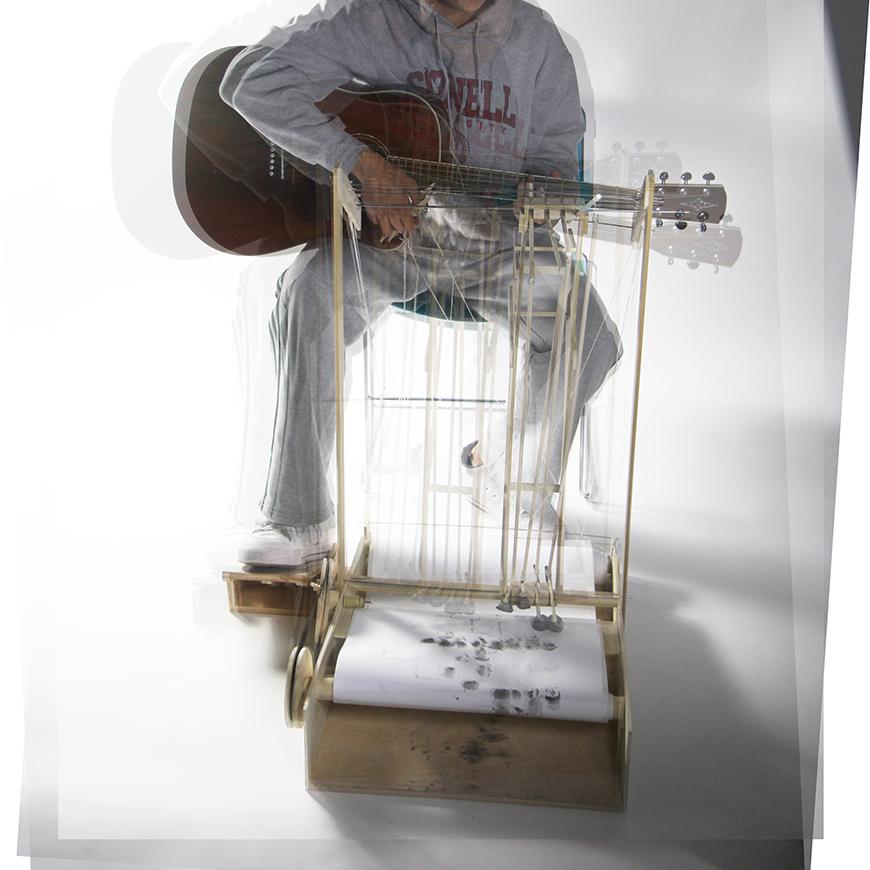 Time lapse photograph of a drawing machine propelled by a guitar. 