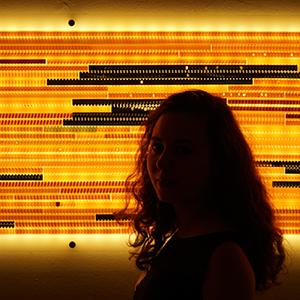 shadow portrait of a person in front of a orange black striped screen