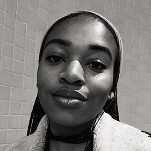 Black and White portrait of a young woman with long hair, wearing a light colored shirt. 