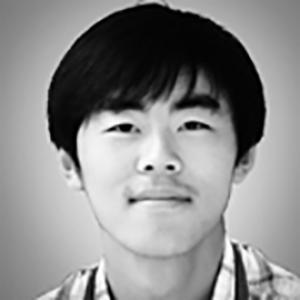 headshot of a young man with dark hair wearing a plaid shirt