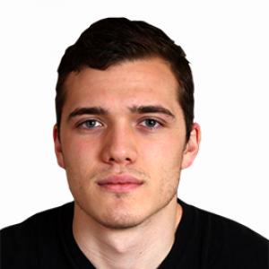 headshot of young man with dark hair wearing a black sweater