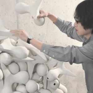 person adding white sculpture to a pile of similar sculptures