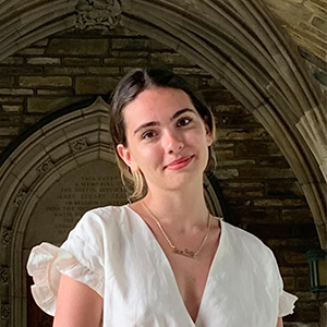 woman in white dress with arched hallway in background