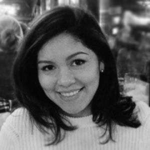black and white photo of a young woman with dark hair wearing a white sweater