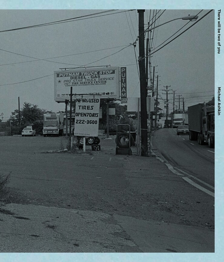 Light blue book cover featuring a black and white photograph of a road-side sign.