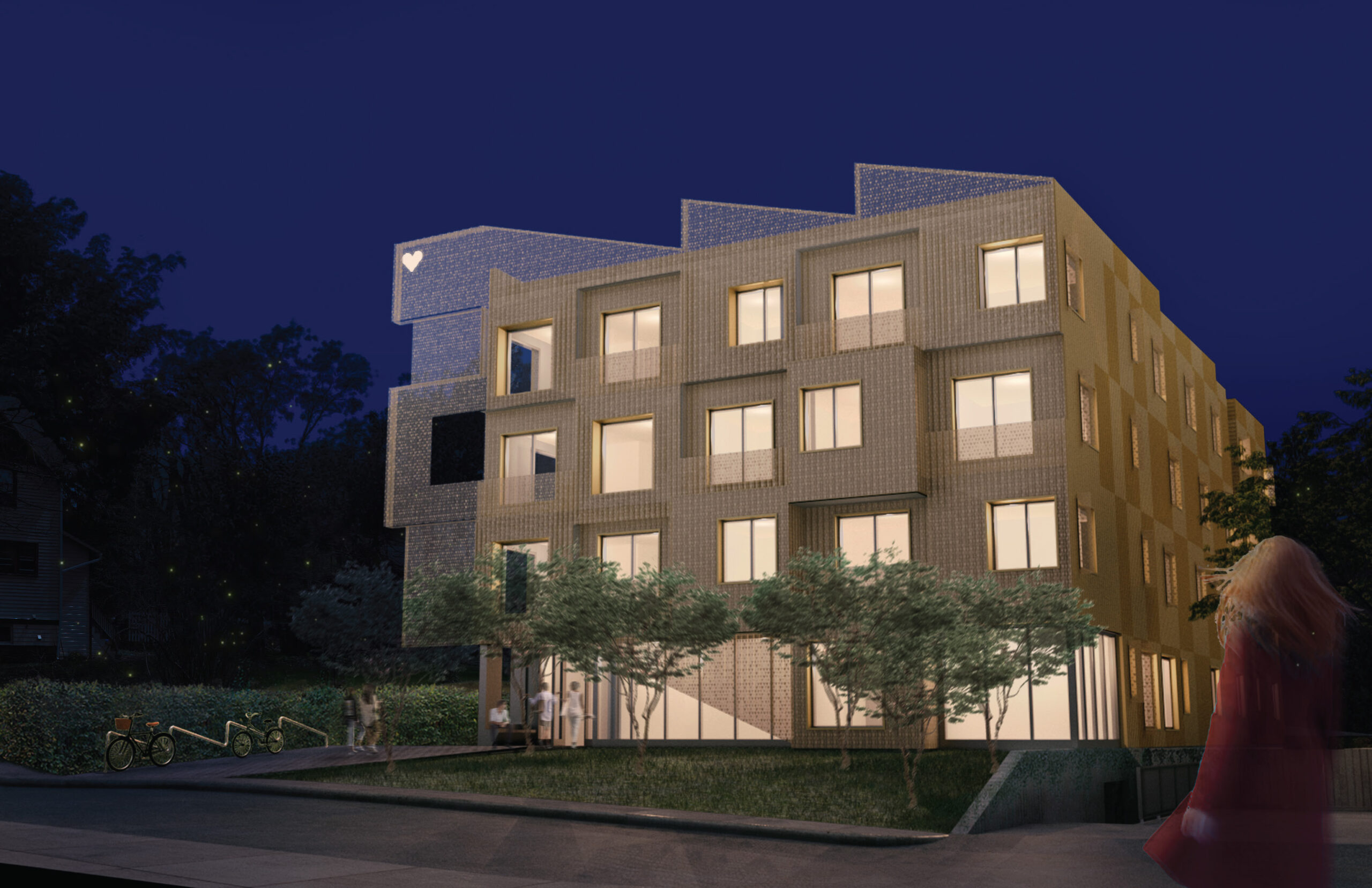 Beige residential building illuminated at night with trees and grass surrounding the structure.