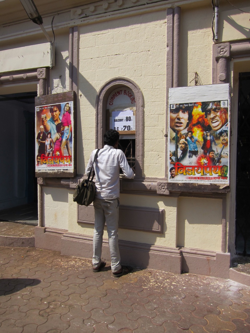 Person buying a movie ticket from an exterior window