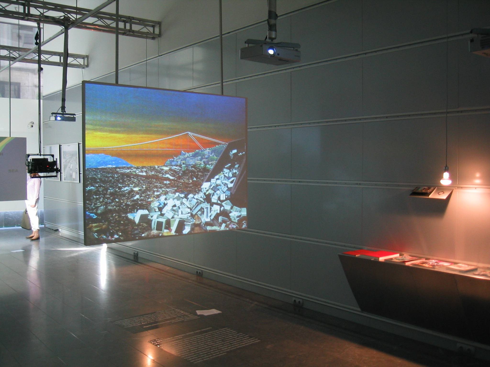 Gray industrial room with projection of a garbage dump on a floating screen