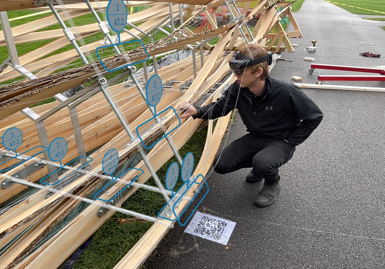 Wooden beams with metal braces are on a sidewalk with a person using mixed reality glasses staring at the beams