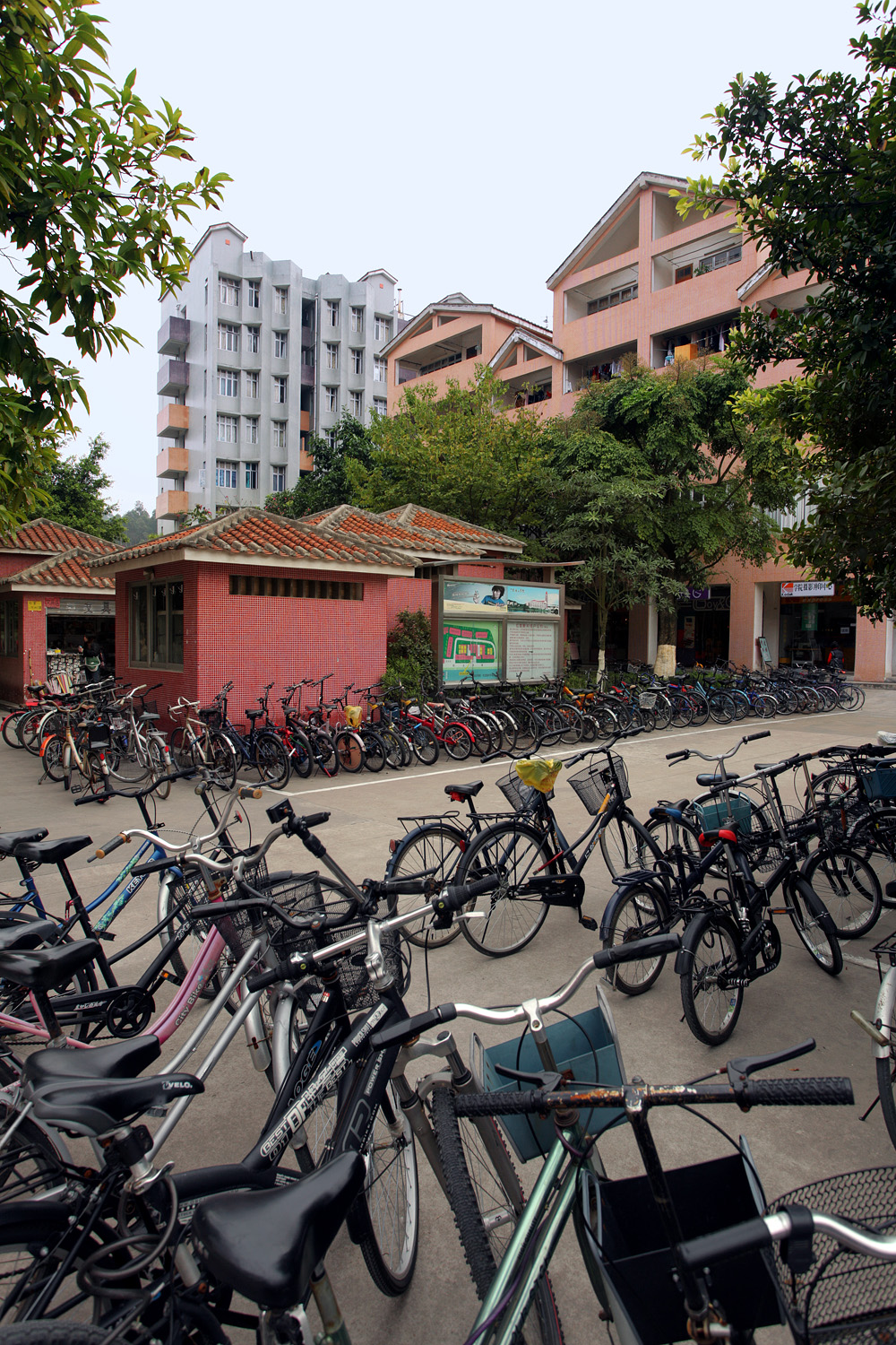 Bikes line the sidewalk in front of small kiosk buildings.
