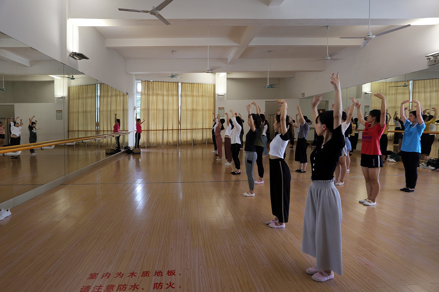 Students hold a dance pose in a studio.