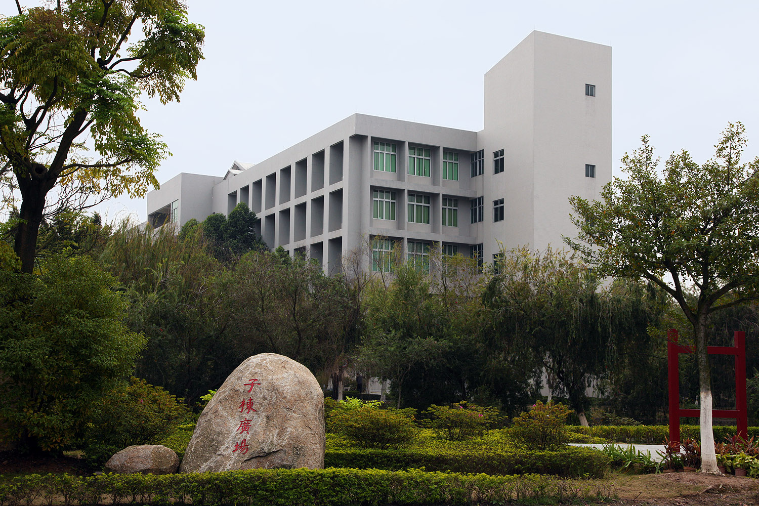 Exterior view of the east side of a rectangular building with a tall, rectangular tower. Many windows line the building's walls, creating a grid-like design.
